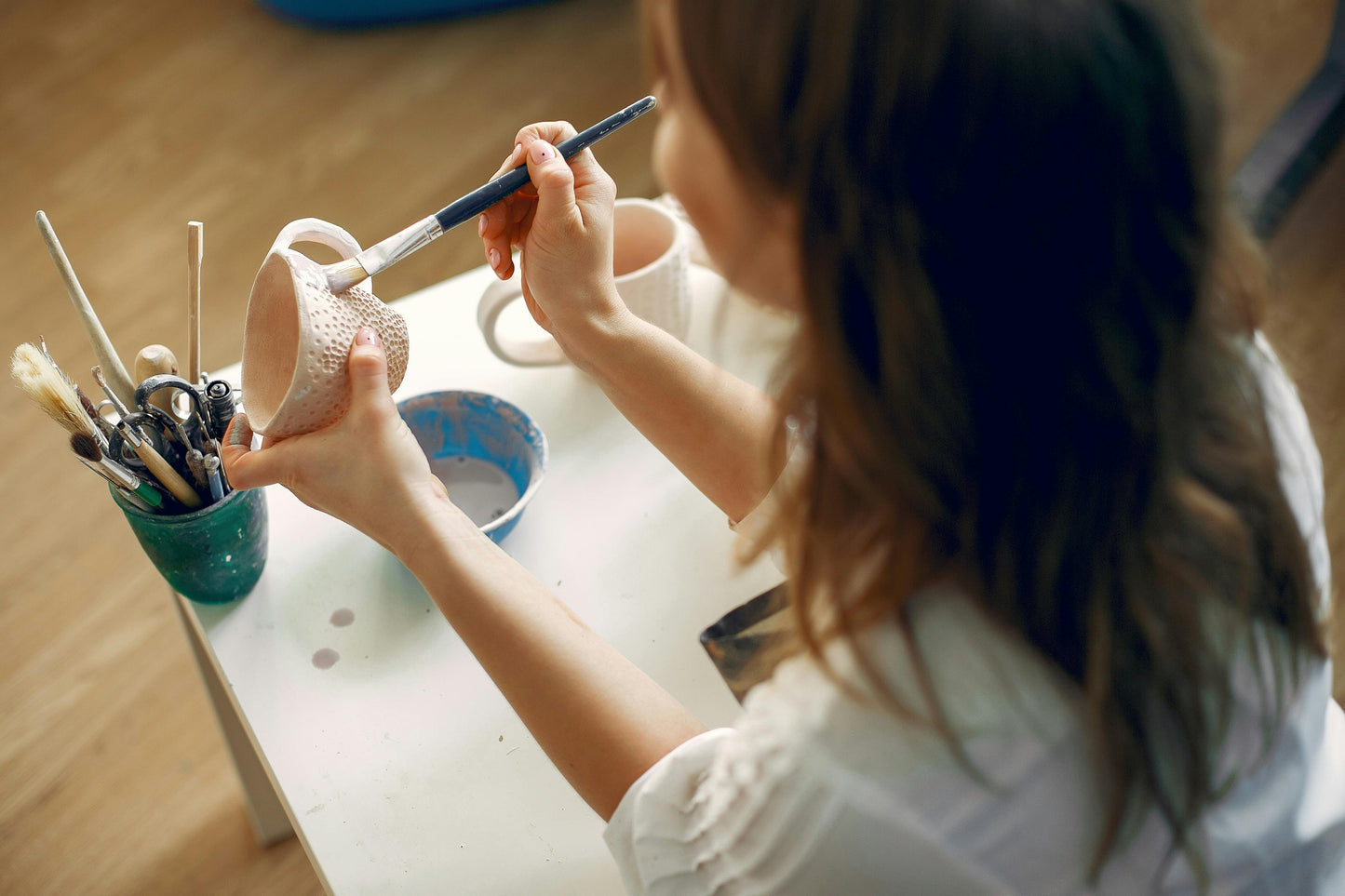 Person glazing a textured mug with a brush
