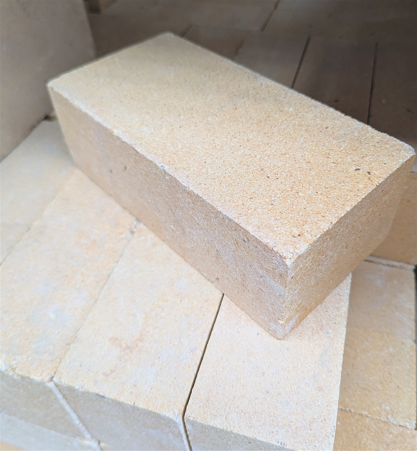 pale solid rick stiilng at an angle on top of other matching bricks
